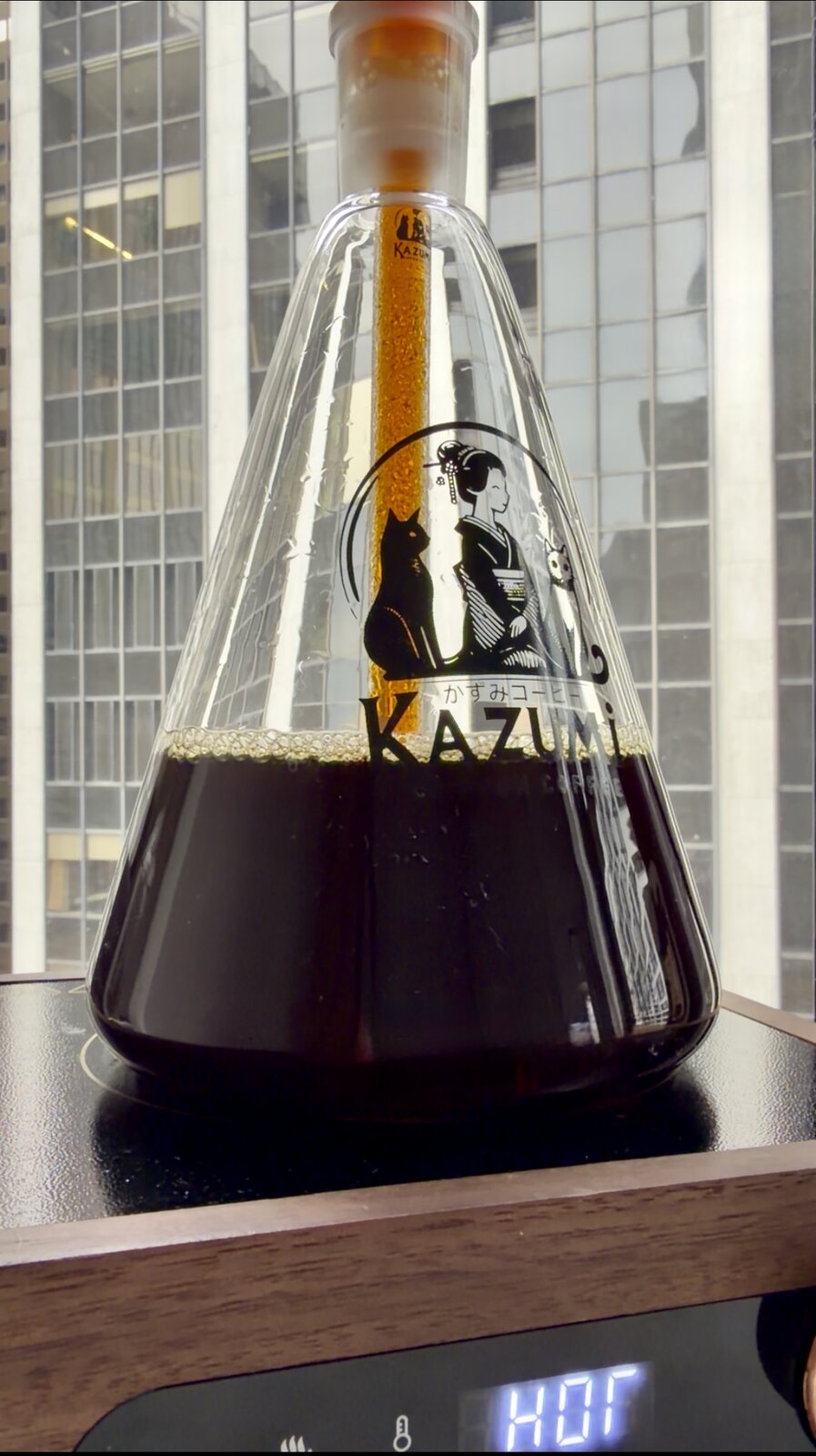 Kazumi all-glass vacuum coffee maker brewing dark coffee in the borosilicate flask